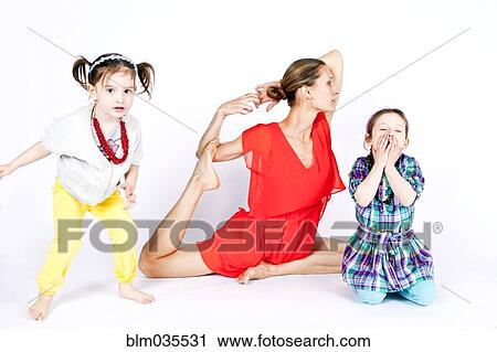 Mother practicing yoga with playful daughters View Large Photo Image Stock Image - Mother practicing yoga with playful daughters. Fotosearch