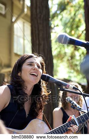 Stock Image - Musicians performing on stage outdoors. Fotosearch