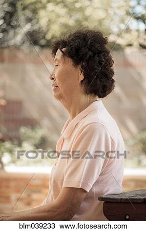 Older Asian woman sitting at picnic table View Large Photo Image Stock Image - Older Asian woman sitting at picnic table. Fotosearch