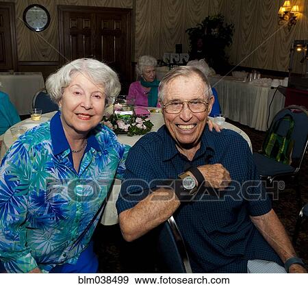 Stock Photo - Older Caucasian couple smiling at party in retirement home. Fotosearch