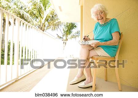 Older Caucasian solving crossword puzzle on balcony View Large Photo Image Stock Photograph - Older Caucasian solving crossword puzzle on balcony. Fotosearch