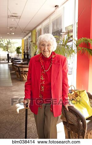 Picture - Older Caucasian walking with cane in retirement home. Fotosearch