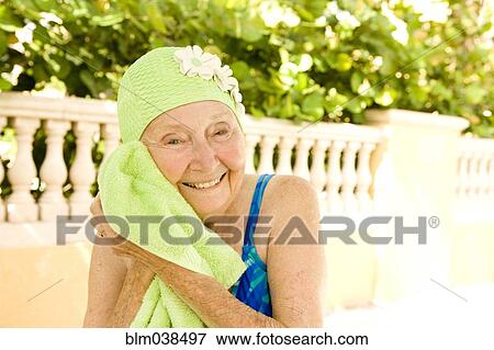 Stock Photo - Older Caucasian woman drying with towel after swimming. Fotosearch