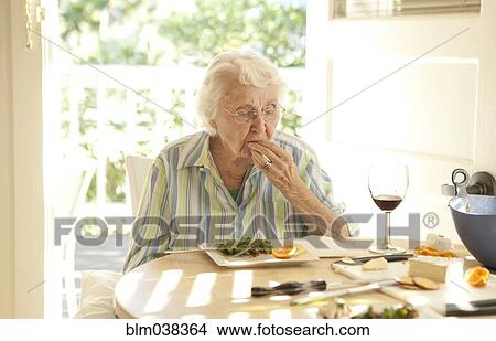 Picture - Older Caucasian woman eating lunch at table. Fotosearch