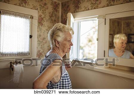 Older Caucasian woman examining herself in mirror View Large Photo Image Stock Image - Older Caucasian woman examining herself in mirror. Fotosearch