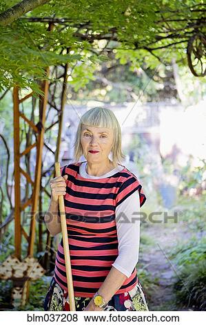 Older Caucasian woman gardening in backyard View Large Photo Image Stock Photo - Older Caucasian woman gardening in backyard. Fotosearch