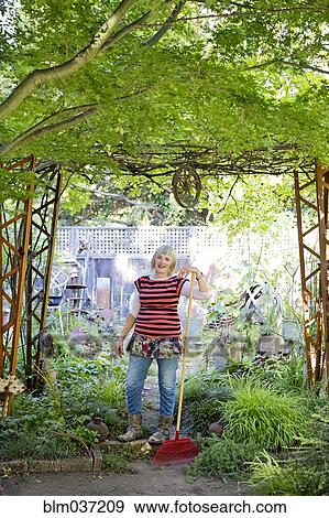 Older Caucasian woman gardening in backyard View Large Photo Image Stock Photo - Older Caucasian woman gardening in backyard. Fotosearch