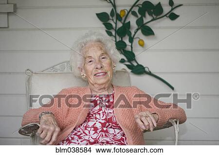 Picture - Older Caucasian woman sitting on patio. Fotosearch