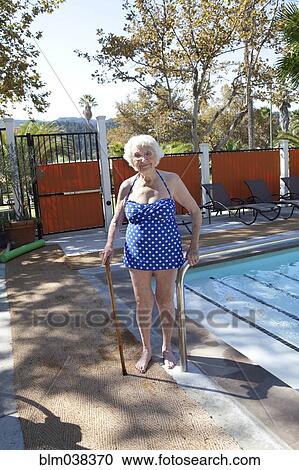 Older Caucasian woman standing with cane near swimming pool View Large Photo Image Stock Image - Older Caucasian woman standing with cane near swimming pool. Fotosearch