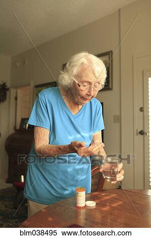 Stock Photography - Older Caucasian woman taking medication. Fotosearch
