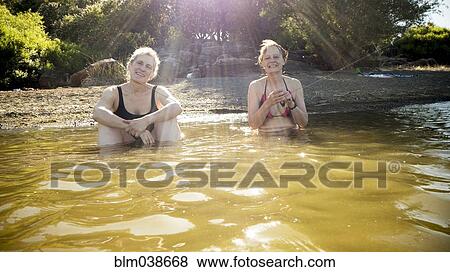 Older Caucasian women sitting in rural pond View Large Photo Image Stock Photo - Older Caucasian women sitting in rural pond. Fotosearch