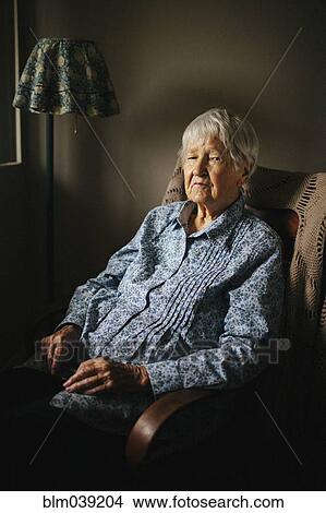 Picture - Older mixed race woman sitting in armchair. Fotosearch