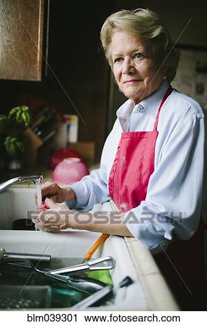 Older woman washing dishes in kitchen sink View Large Photo Image Stock Image - Older woman washing dishes in kitchen sink. Fotosearch