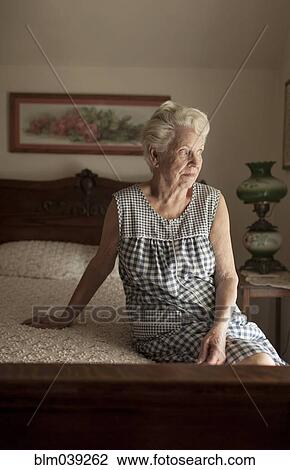 Pensive older woman sitting on bed View Large Photo Image Stock Image - Pensive older woman sitting on bed. Fotosearch