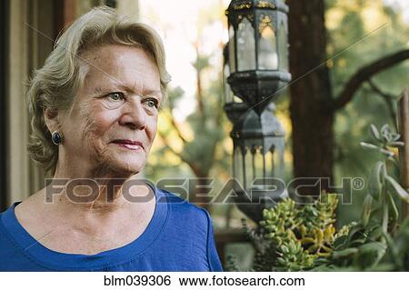 Pensive older woman standing on porch View Large Photo Image Stock Photograph - Pensive older woman standing on porch. Fotosearch