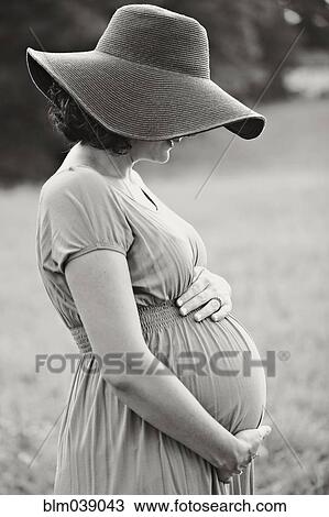 Pregnant Caucasian woman holding belly in field View Large Photo Image Stock Image - Pregnant Caucasian woman holding belly in field. Fotosearch