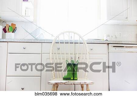 Rain boots of child on chair near kitchen sink View Large Photo Image Stock Photo - Rain boots of child on chair near kitchen sink. Fotosearch