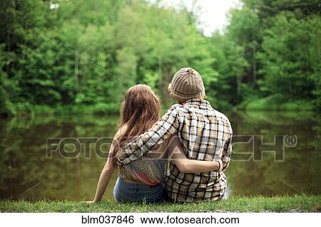 Rear view of couple hugging near lake View Large Photo Image Stock Photograph - Rear view of couple hugging near lake. Fotosearch