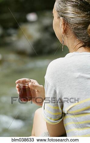 Rear view of woman drinking cocktail outdoors View Large Photo Image Stock Image - Rear view of woman drinking cocktail outdoors. Fotosearch