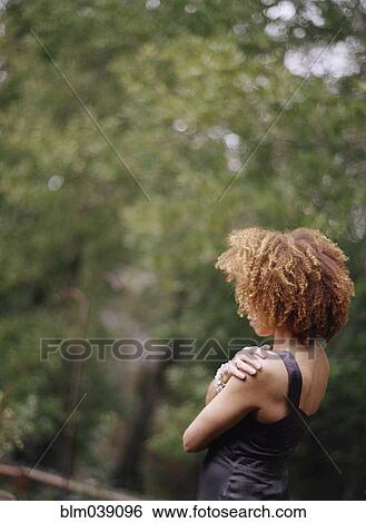 Stock Photograph - Rear view woman admiring forest view. Fotosearch