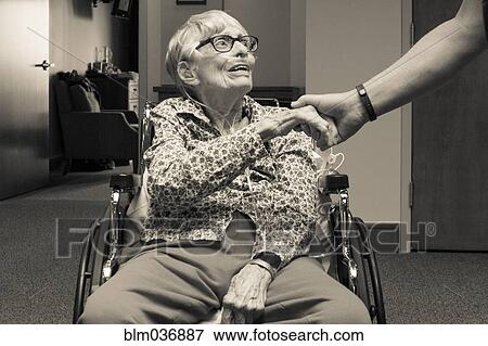 Senior woman in wheelchair shaking hand of man View Large Photo Image Stock Photo - Senior woman in wheelchair shaking hand of man. Fotosearch