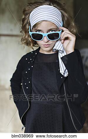 Serious girl peering over sunglasses View Large Photo Image Stock Photo - Serious girl peering over sunglasses. Fotosearch