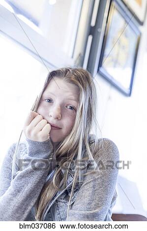 Stock Photograph - Serious girl resting chin in hand. Fotosearch