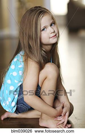 Stock Photograph - Serious girl sitting on floor. Fotosearch