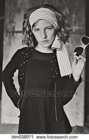 Stock Image - Serious girl standing with hands on hips. Fotosearch