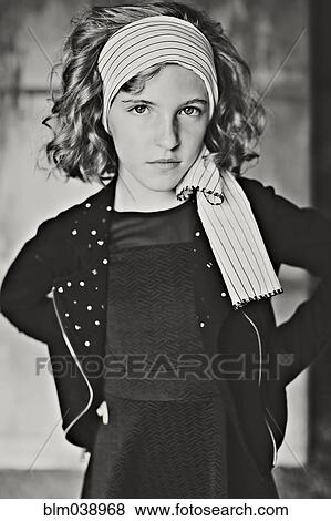 Stock Photo - Serious girl standing with hands on hips. Fotosearch