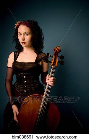 Serious musician holding cello View Large Photo Image Stock Image - Serious musician holding cello. Fotosearch