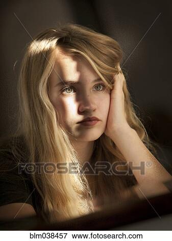 Stock Photo - Serious teenage girl examining herself in mirror. Fotosearch