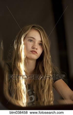 Serious teenage girl examining herself in mirror View Large Photo Image Stock Photo - Serious teenage girl examining herself in mirror. Fotosearch