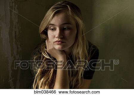 Serious teenage girl sitting by window View Large Photo Image Stock Photograph - Serious teenage girl sitting by window. Fotosearch