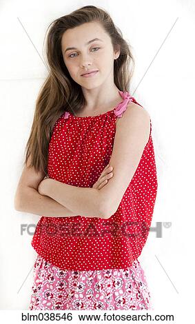 Stock Photograph - Serious teenage girl standing with arms crossed. Fotosearch