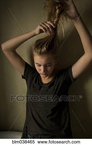 Serious teenage girl twisting her hair View Large Photo Image Stock Photography - Serious teenage girl twisting her hair. Fotosearch