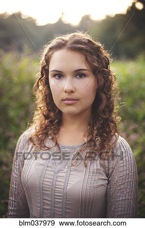 Stock Photo - Serious woman standing in rural field. Fotosearch