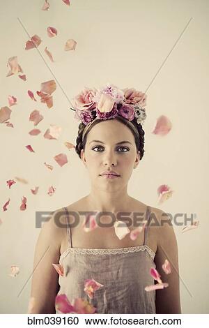 Stock Image - Serious woman wearing flowers in her hair. Fotosearch