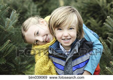 Siblings hugging near pine trees View Large Photo Image Stock Photo - Siblings hugging near pine trees. Fotosearch