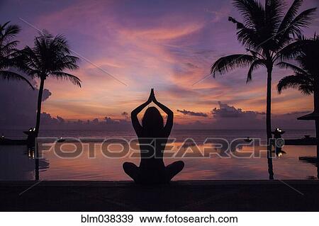 Silhouette of woman meditating near swimming pool at sunset View Large Photo Image Stock Photo - Silhouette of woman meditating near swimming pool at sunset. Fotosearch