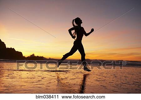 Silhouette of woman running on beach at sunset View Large Photo Image Stock Image - Silhouette of woman running on beach at sunset. Fotosearch
