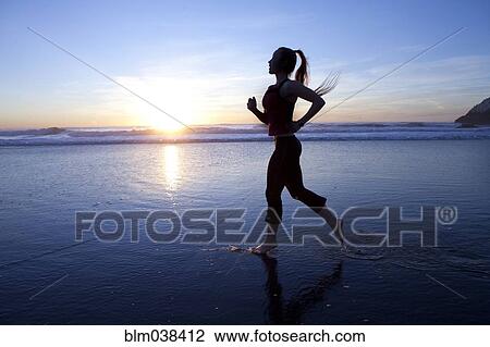 Silhouette of woman running on beach at sunrise View Large Photo Image Stock Image - Silhouette of woman running on beach at sunrise. Fotosearch