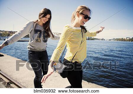 Sisters exploring waterfront View Large Photo Image Stock Image - Sisters exploring waterfront. Fotosearch