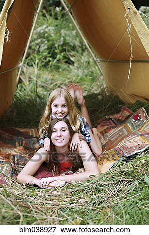 Stock Photo - Sisters laying in camping tent. Fotosearch