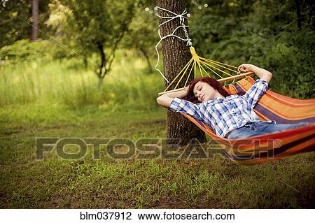 Stock Image - Sleeping girl laying in hammock. Fotosearch