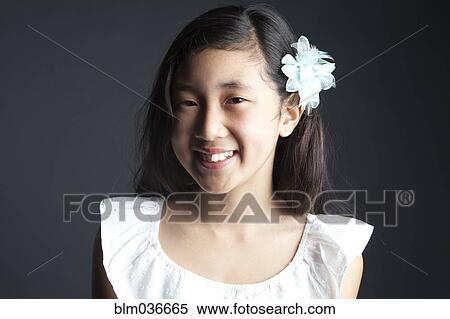 Smiling Asian girl wearing flower in her hair View Large Photo Image Stock Photography - Smiling Asian girl wearing flower in her hair. Fotosearch