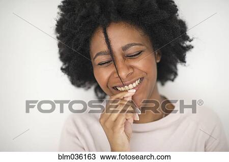 Smiling Black woman playing with hair View Large Photo Image Stock Image - Smiling Black woman playing with hair. Fotosearch