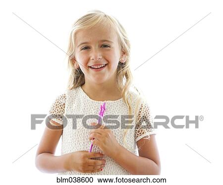 Stock Image - Smiling Caucasian girl holding fairy wand. Fotosearch