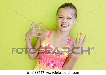 Stock Photo - Smiling Caucasian teenage girl displaying fingernails. Fotosearch