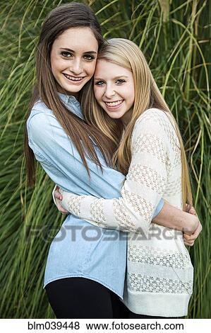 Stock Photo - Smiling Caucasian teenage girls hugging. Fotosearch